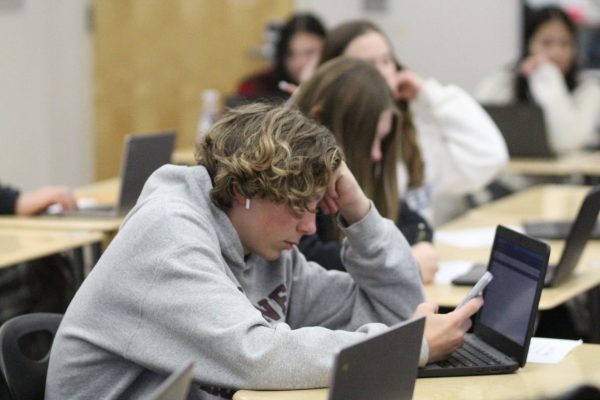 In Mrs. Ashley Just’s seventh-period ASL I class on February 8, Zion Hoehne looks at his phone while other students work on the study guide for their Unit 3 test. Photo by Lauren Willis.
