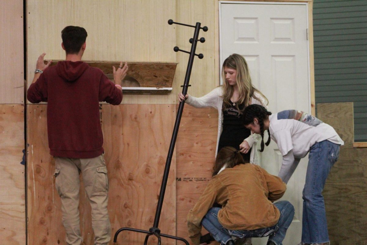 Returning set pieces to their original spots, cast members reset the set to film a promotional video for the play. Students arrived during PAWS Oct. 18 to first rehearse how the video would be shot and then filmed it. Photo by Riley Rust